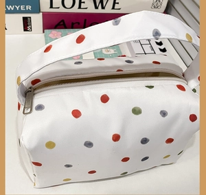 Macro shot of large capacity colorful polka dot plush toiletry bag with zipper and handle