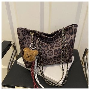 Détail du sac cabas léopard avec bandoulière en chaîne dorée et breloque ours marron