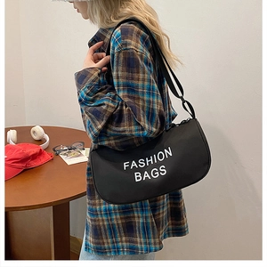 Detail of black nylon shoulder bag with Fashion Bags print and adjustable strap