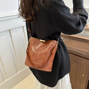 Sac seau rétro marron avec poignée tissée et bandoulière vu de profil par le côté
