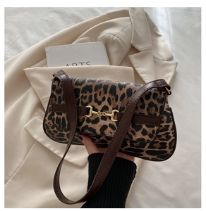 Detail of vintage leopard print shoulder bag featuring a gold horsebit buckle and leather strap