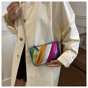 Close-up of rainbow striped crossbody bag featuring metallic lychee texture and silver rivets