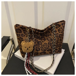 Détail du sac cabas léopard avec pendentif ours en peluche et bandoulière en chaîne