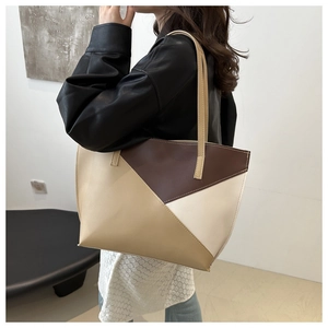 Detail view showing the color block tote bag worn as a shoulder bag in a minimalist setting