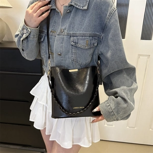 Sac seau rétro noir brillant pour femme avec poignée tressée et détails dorés