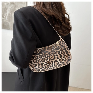 Vue latérale d'un sac hobo tendance à imprimé léopard porté avec un blazer noir