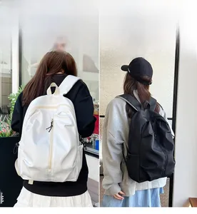 Detail showing white and black minimalist backpacks with vertical front zippers
