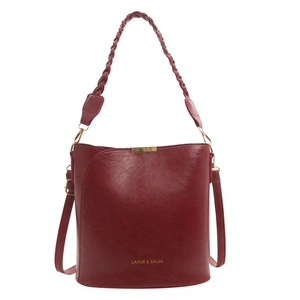 Sac seau rouge vintage avec texture cirée, détails dorés et anse tressée