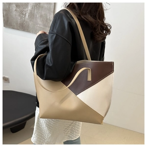 Detail view of large color-block tote bag in brown and beige leather patchwork