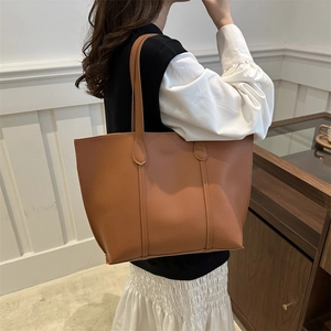 Detailed view of the large brown leather tote bag showing smooth texture and spacious design
