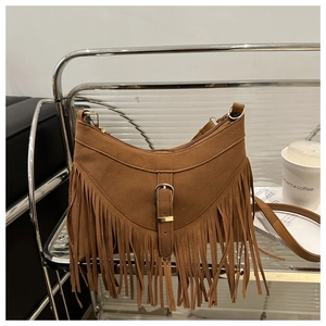 Dettaglio borsa tote in pelle scamosciata marrone con frange e fibbia in metallo dorato boho