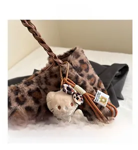 Dettaglio della borsa leopardata in ecopelliccia con manico intrecciato e ciondolo