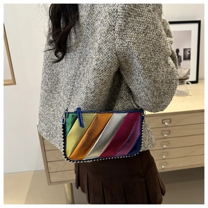Detail of colorful metallic rainbow striped shoulder bag with silver studded base and chain