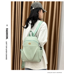 Detail of light green nylon backpack showing large capacity pocket and soft material texture