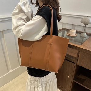 Brown leather large tote bag for women shown in a cozy indoor lifestyle setting