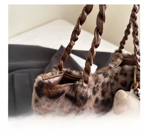 Dettaglio della borsa leopardata in ecopelliccia con manici a treccia e charm