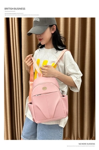 Detail of pink waterproof nylon backpack featuring multiple pockets and casual strap design