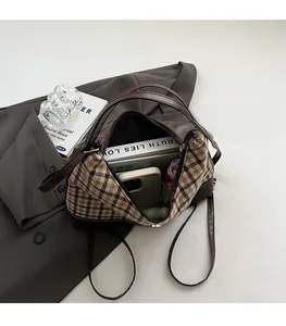 Detail view of the spacious interior of a brown canvas tote bag with side plaid patterns