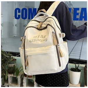 Detail of a large capacity cream backpack showing nylon fabric and khaki zipper accents