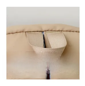 Detail of comfortable woven handle with reinforced stitching on minimalist khaki backpack