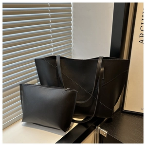 Minimalist black leather tote set showing large shoulder bag and matching pouch