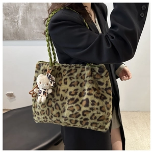 Dettaglio della borsa tote in peluche leopardata verde con manico intrecciato