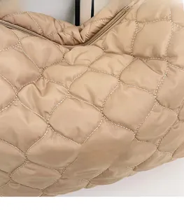 Dettaglio della borsa tote in nylon trapuntato kaki con motivo a rombi e zip in metallo
