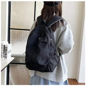 Student backpack back view showing large capacity and side compression buckles on black nylon