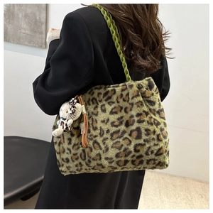 Dettaglio borsa tote leopardata in peluche con manico in corda verde e ciondolo a gatto