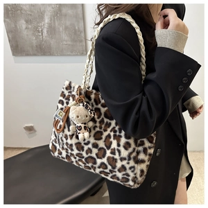 Dettaglio borsa tote in peluche leopardata con manici intrecciati e ciondolo decorativo