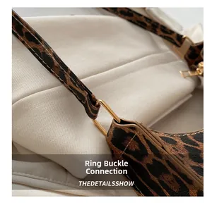 Detailed macro view of the leopard print handbag showing golden ring buckles and stitching