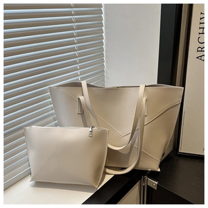 Detail of off-white tote bag set with geometric stitching and matching small pouch