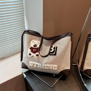 Vintage canvas tote bag with brown leather trim and bear patch for daily commuting