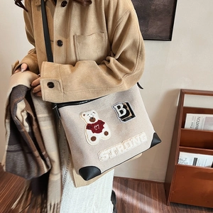 Retro canvas tote bag with bear patch and leather corners shown in a crossbody style