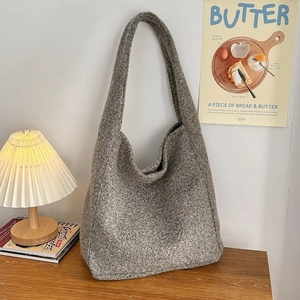 Detailtextur der grauen Lammwoll-Tasche in gemütlicher häuslicher Umgebung