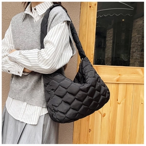 Dettaglio della texture in nylon trapuntato nero e delle cuciture sulla borsa tote