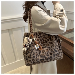 Dettaglio borsa tote leopardata in peluche con manico intrecciato e ciondolo a forma di orso