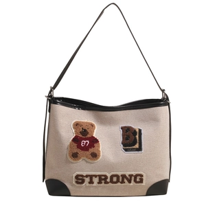 Retro canvas tote bag with bear patches and 'STRONG' embroidery in a minimalist setup