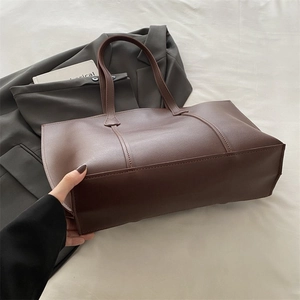 Detail view of large brown contrast tote bag with premium faux leather texture for work