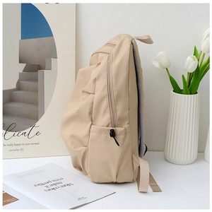 Side view of beige nylon backpack showing side pocket and durable zipper detail