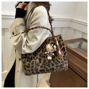 Dettaglio della borsa tote leopardata in peluche con tracolla a catena e charm