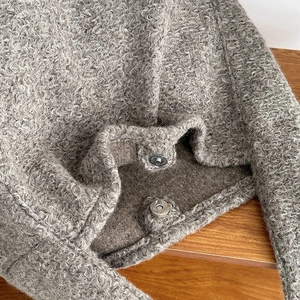 Detailaufnahme der graubraunen Lammwoll-Tasche mit metallischem Magnetverschluss