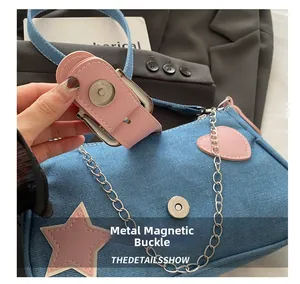 Détail du sac à bandoulière en denim montrant la fermeture à bouton pression magnétique
