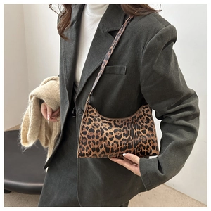 Close-up of leopard print shoulder bag styled with vintage corduroy blazer and scarf