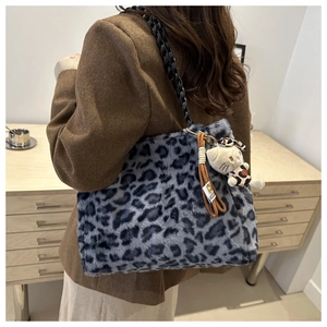 Dettaglio della borsa tote leopardata in peluche con catena nera e ciondolo a gatto