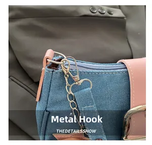 Détail du crochet argenté et de la chaîne sur sac en jean et cuir rose