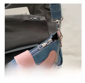 Gros plan détaillé de la fermeture éclair en métal argenté du sac porté épaule en jean