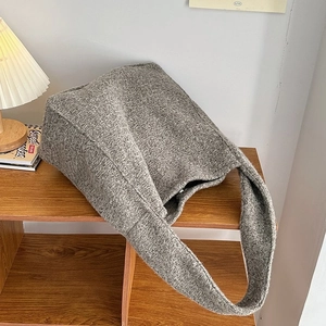 Detailansicht der grauen Tweed-Einkaufstasche im Regal mit warmem Umgebungslicht