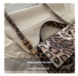 Nahaufnahme der goldenen Metallschnalle und Leopardenmuster auf der Handtasche