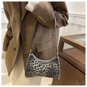 Close-up of leopard print baguette bag featuring canvas texture and vintage zipper strap